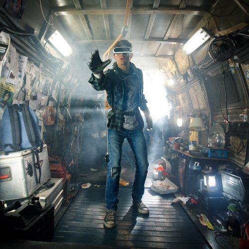 In his dystopian home, the main character of Ready Player One wears a virtual reality headset and reaches towards the virtual world.